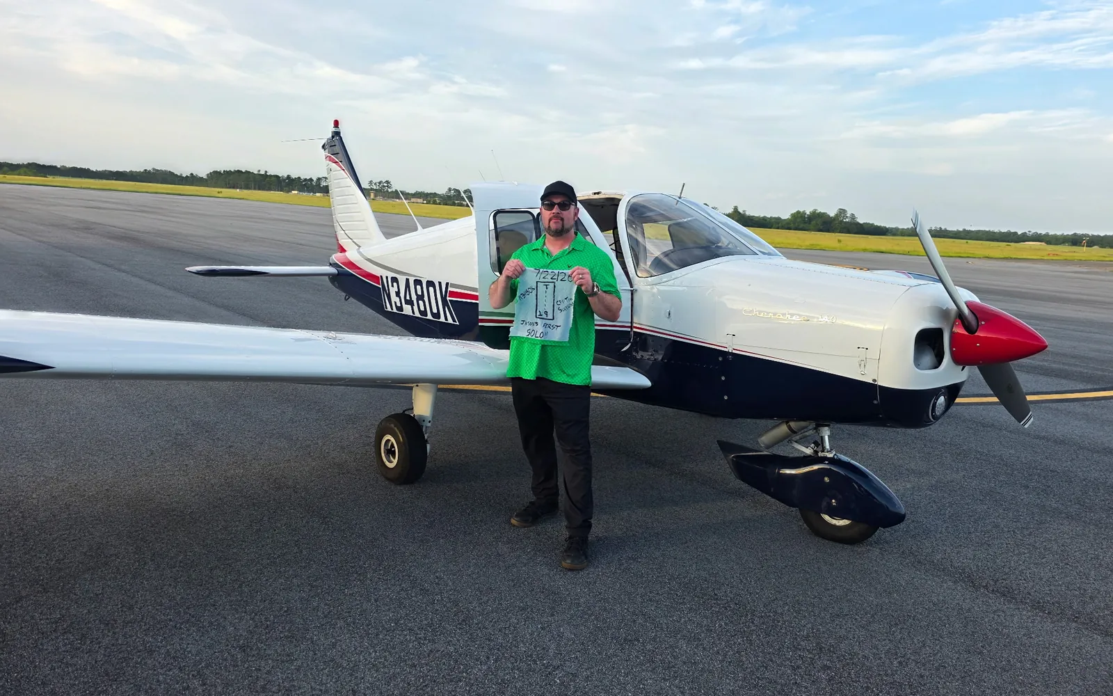 VA Ready founder Jason on the ramp beside Piper Cherokee 140 N3480K, holding the signed shirttail from his first solo flight